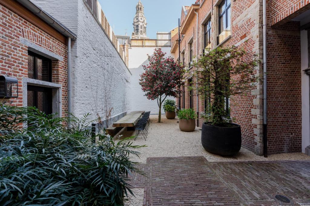 安特卫普BTFL Living Antwerp的庭院,有长凳,植物和塔楼