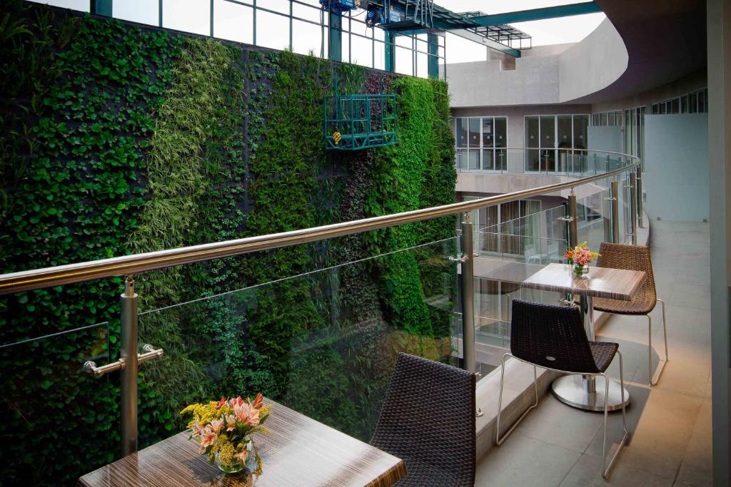 墨西哥城宾夕法尼亚套房酒店的一间设有桌子和绿色墙壁的房间