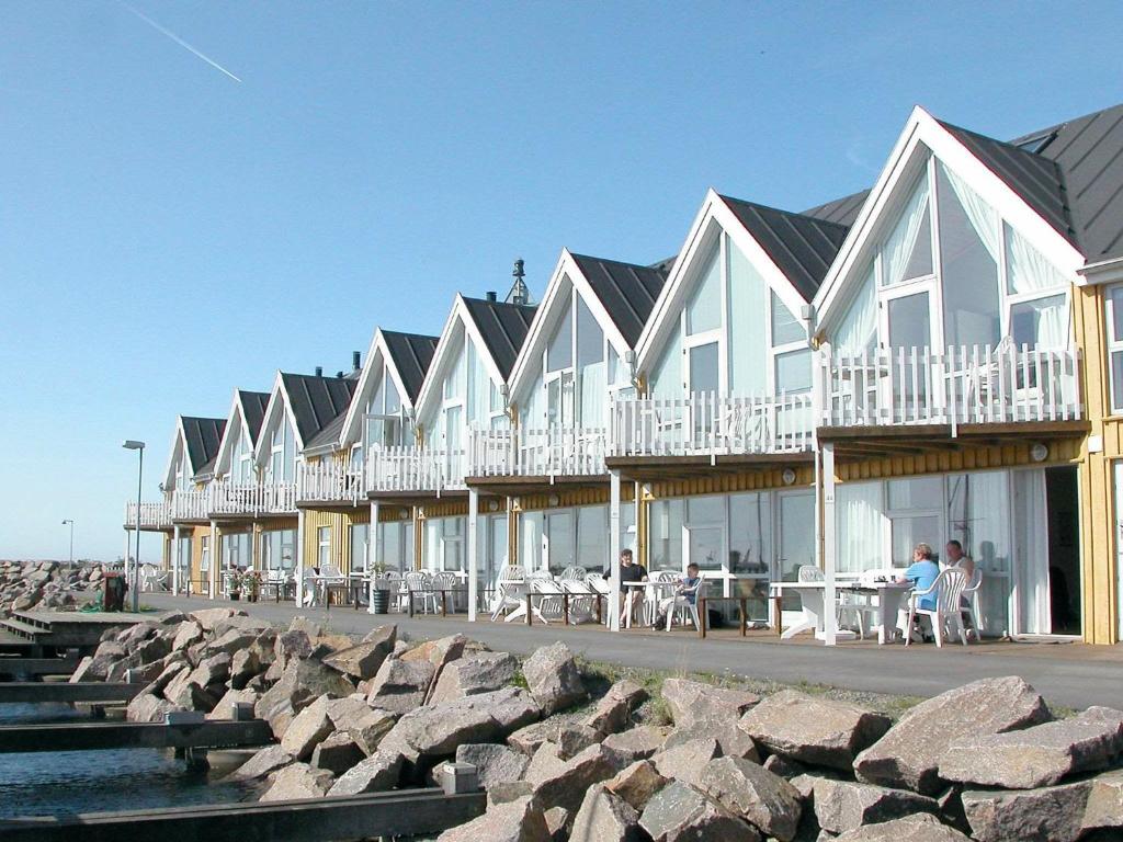 海斯勒6 person holiday home in Hasle的海滩上一排配有桌椅的房屋