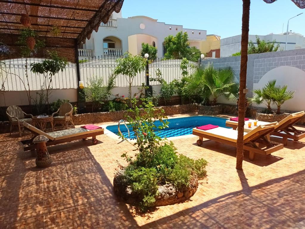 赫尔格达Rum i villa med pool的后院设有带桌子和长凳的游泳池