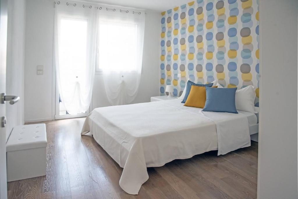 帕多瓦Appartamenti Scrovegni的一间卧室配有白色的床和蓝色和黄色枕头