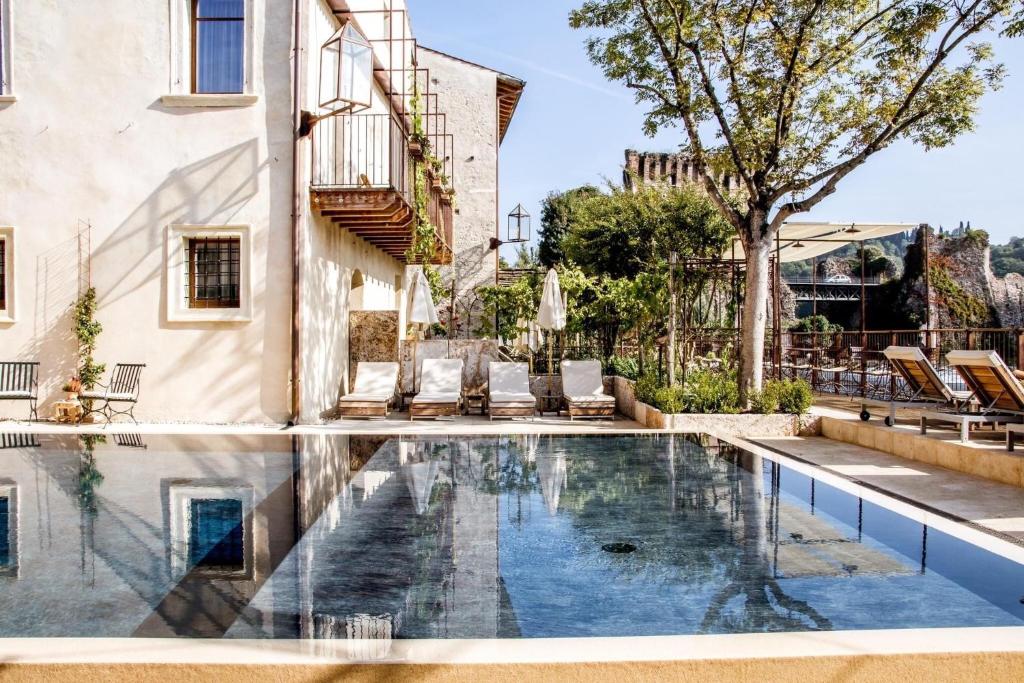 明乔河畔的瓦雷奇奥Corte Regia Relais & Spa的一座房子里游泳池的形象