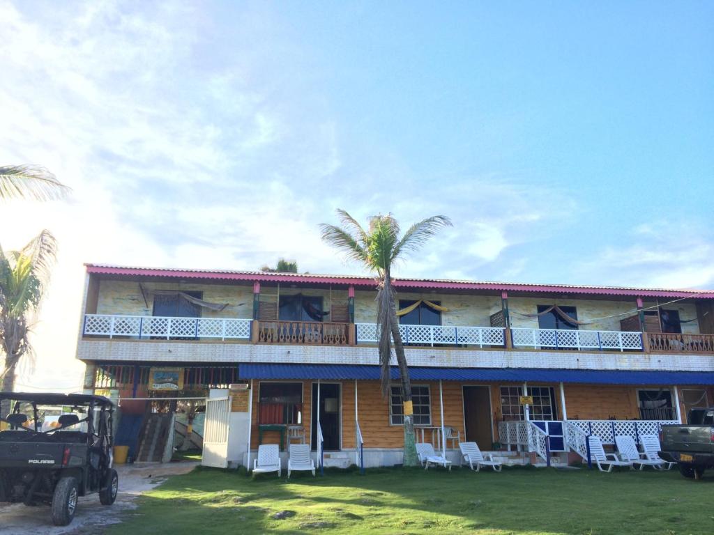 圣安德烈斯Yellow Moon Guesthouse & Apartments的前面有棕榈树的建筑