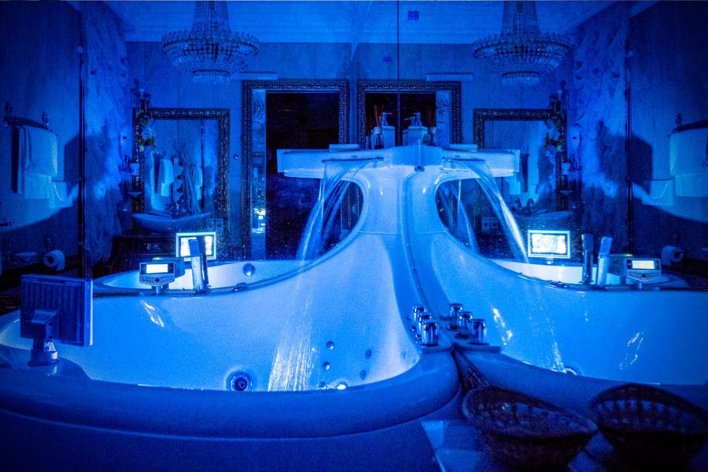 拉默齐亚泰尔默B&Boutique Lamezia Terme的蓝色的浴室设有两个盥洗盆和一个浴缸。