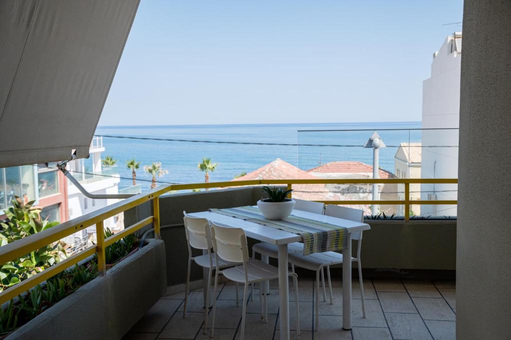 罗希姆诺Eftihia Apartments by the sea的海景阳台上的桌椅
