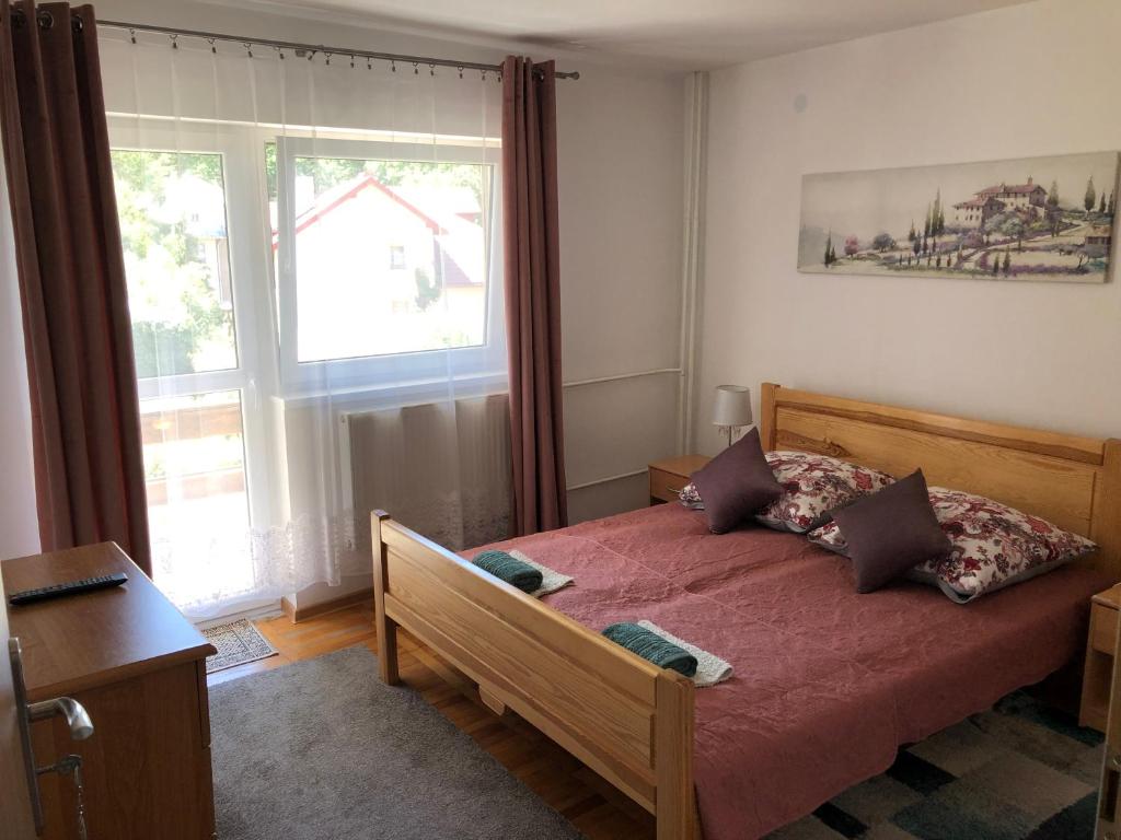 伊沃尼奇-兹德鲁伊Dalia的一间卧室配有一张带红色床单的床和一扇窗户。