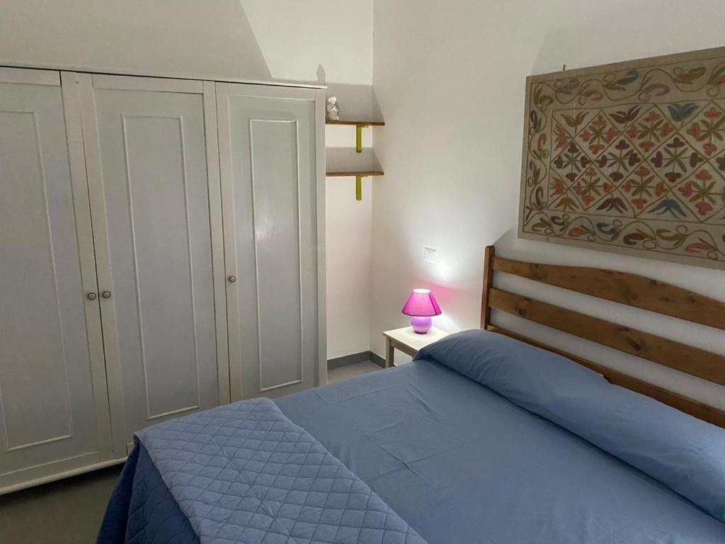 科佩尔蒂诺casa vacanze Riccardo Elisa的一间卧室配有蓝色的床和粉红色的灯