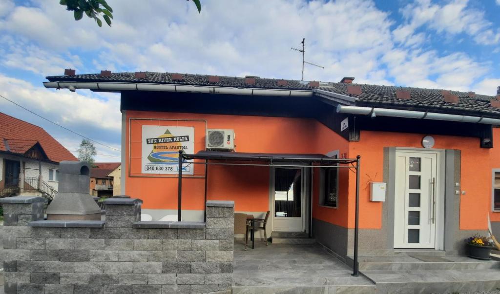 维尼察Sun river Kolpa AP1的一座橙色的小建筑,设有白色的门