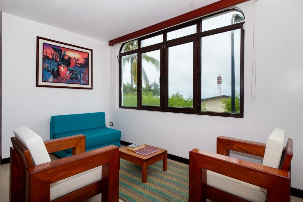 阿约拉港Galapagos Apartments - Bay View House的客厅配有桌椅和窗户。