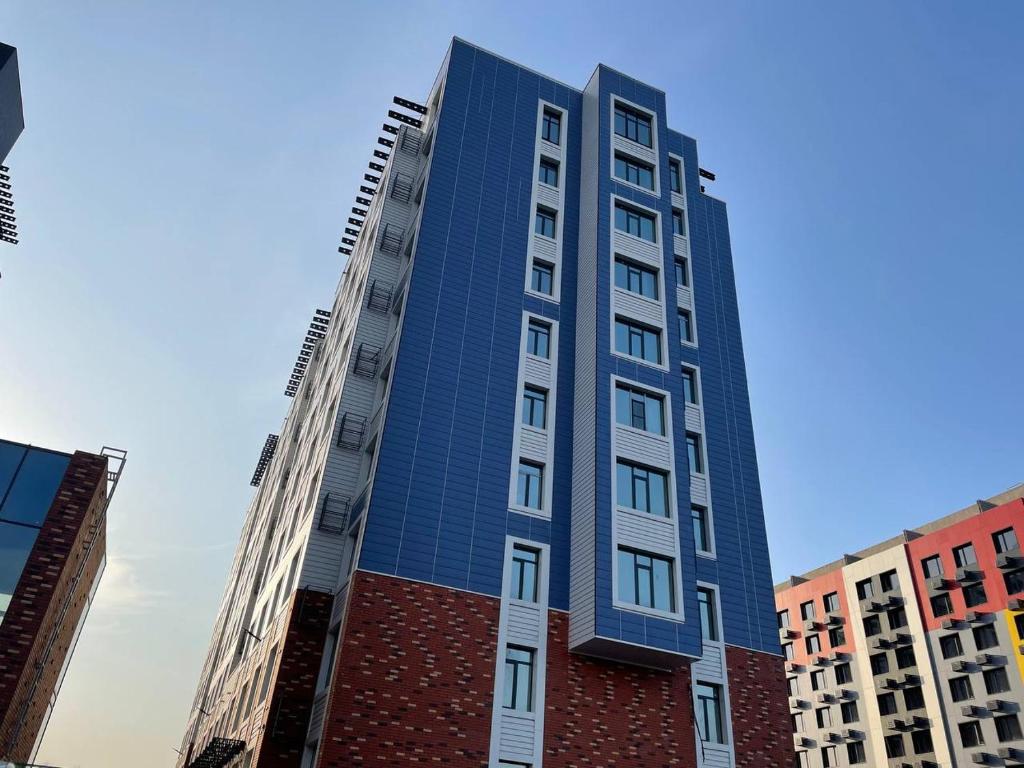 阿拉木图Апартаменты в ЖК Варламова的一座高大的蓝色建筑,有建筑