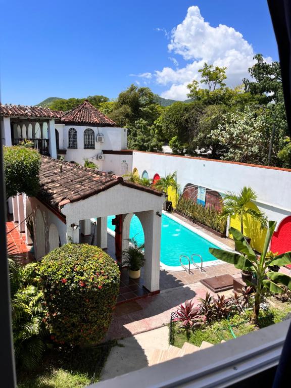 圣玛尔塔The Chill in Mansion Hostel Santa Marta的享有带游泳池的房子的景色