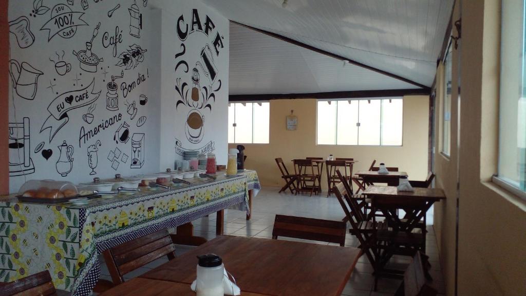 路易斯科雷亚pousada ATALAIA ASFEPI的餐厅设有桌椅,墙上涂鸦