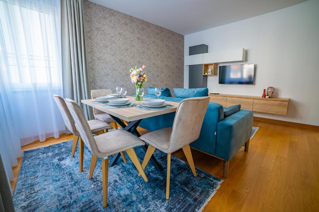 诺维萨德Kedar apartment的一间带桌子和蓝色沙发的用餐室