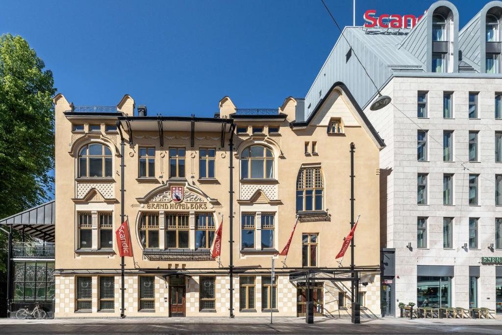 图尔库Scandic Hamburger Börs的大楼前方有旗帜的大建筑