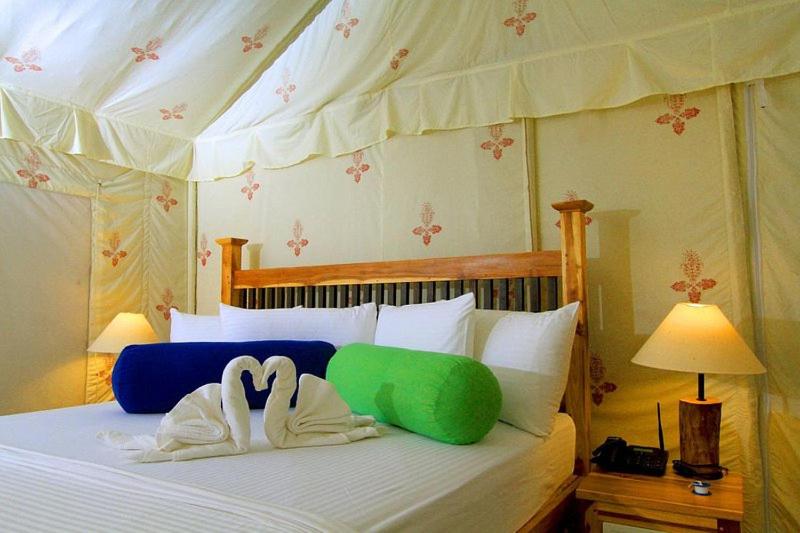 蒂瑟默哈拉默Green villa yala的一间卧室配有一张带两个天鹅枕头的床。