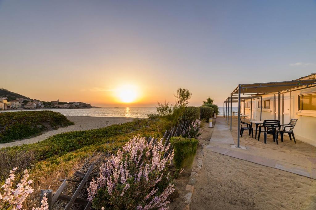 阿尔加约拉莱斯嘉勒海滩酒店的海滩上的房子,背景是日落