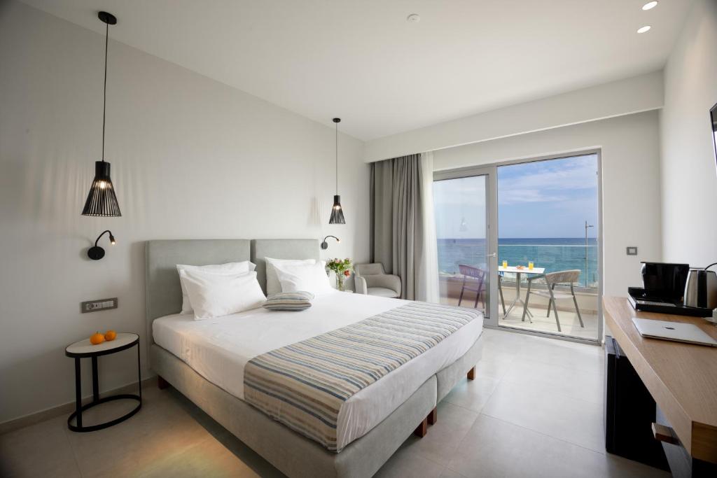 罗希姆诺Batis Beach Hotel的一间卧室配有一张床,享有海景