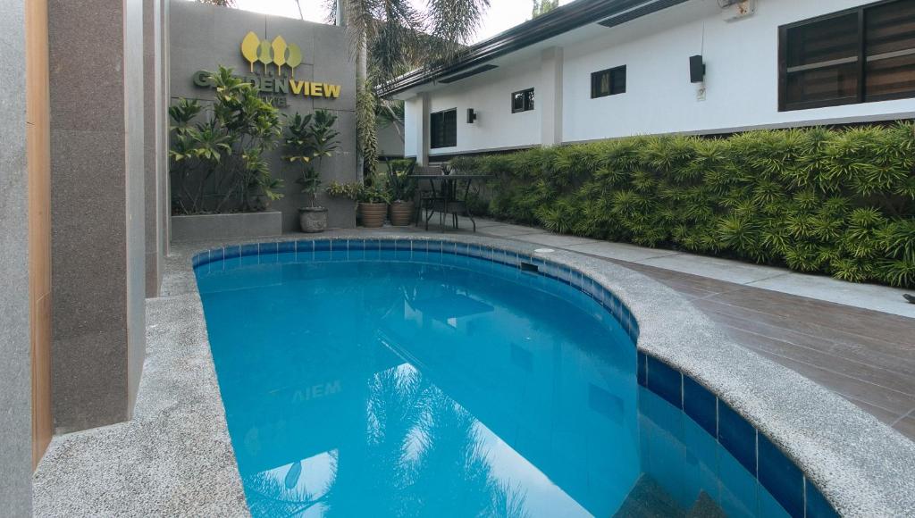 安吉利斯RedDoorz @ Gardenview Hotel GTower Angeles的大楼前的蓝色游泳池