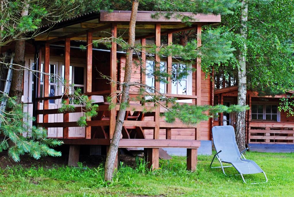 阿尼克什奇艾Laumių Nameliai的小木屋前面设有长凳