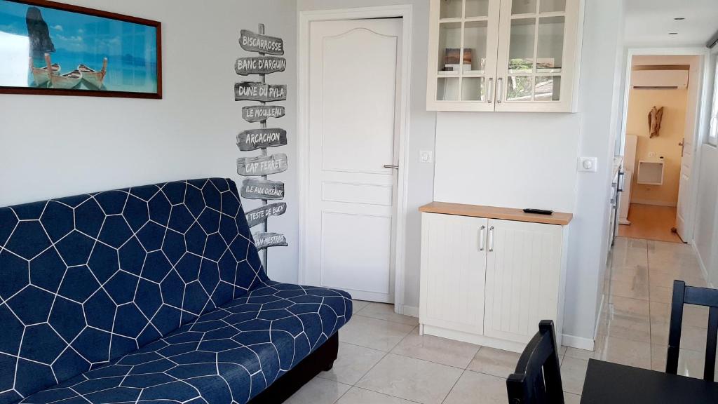 萨莱Maisonnette bois flottés的一间带蓝色沙发的客厅和一间厨房
