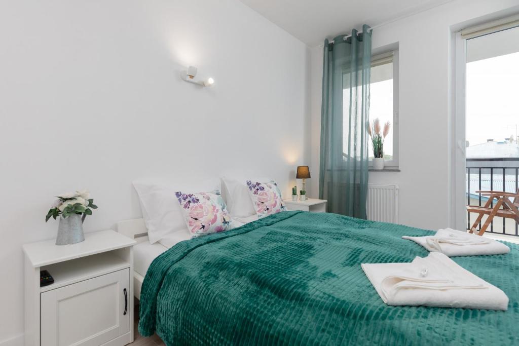 济夫努夫Morska Apartment Dziwnówek by Renters的白色卧室配有绿床和毛巾
