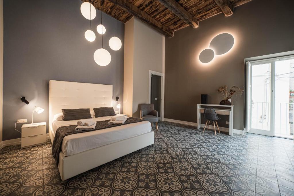 皮佐Palazzo Paladini - Luxury Suites in the Heart of the Old Town的一间卧室配有一张床,墙上有些灯光