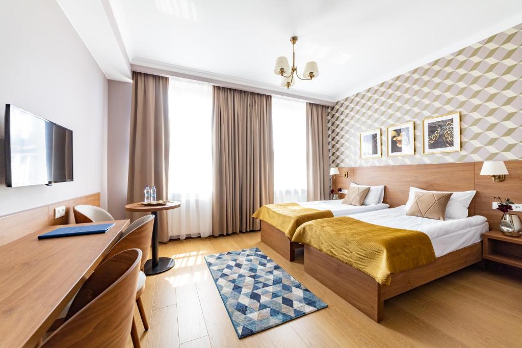 克拉科夫Portal House Apartments的酒店客房配有两张床和一张书桌