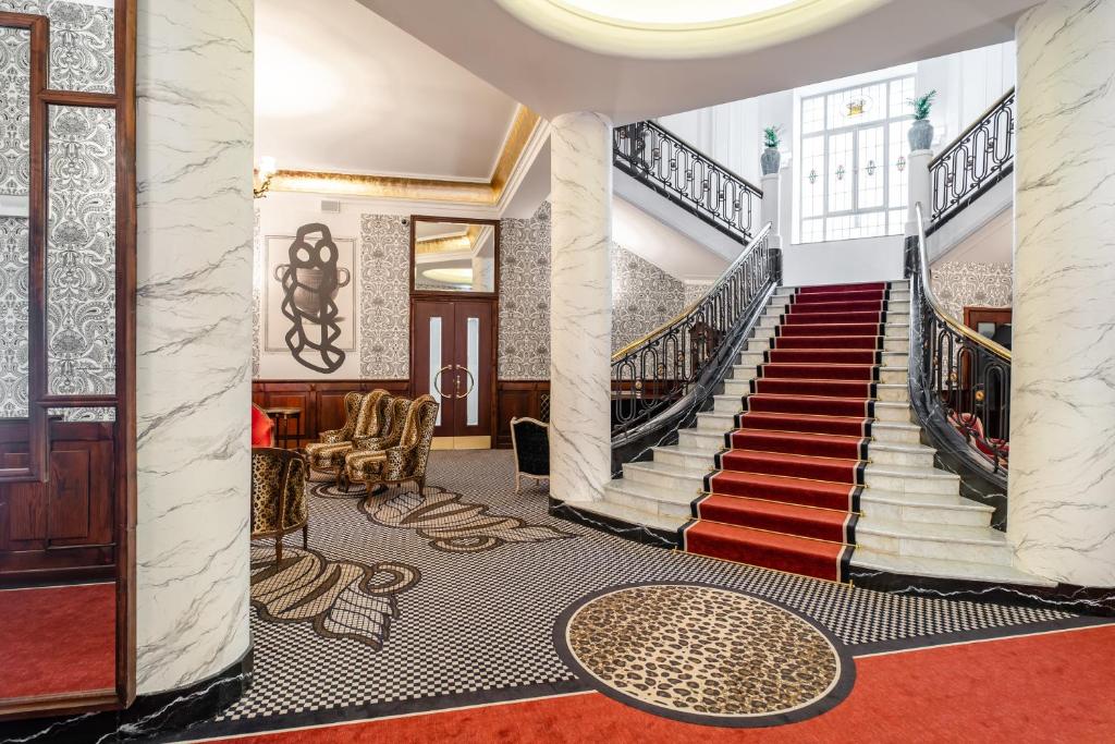 克拉科夫Hotel H15 Francuski Old Town - Destigo Hotels的楼梯,位于一个铺有红地毯的建筑和大堂