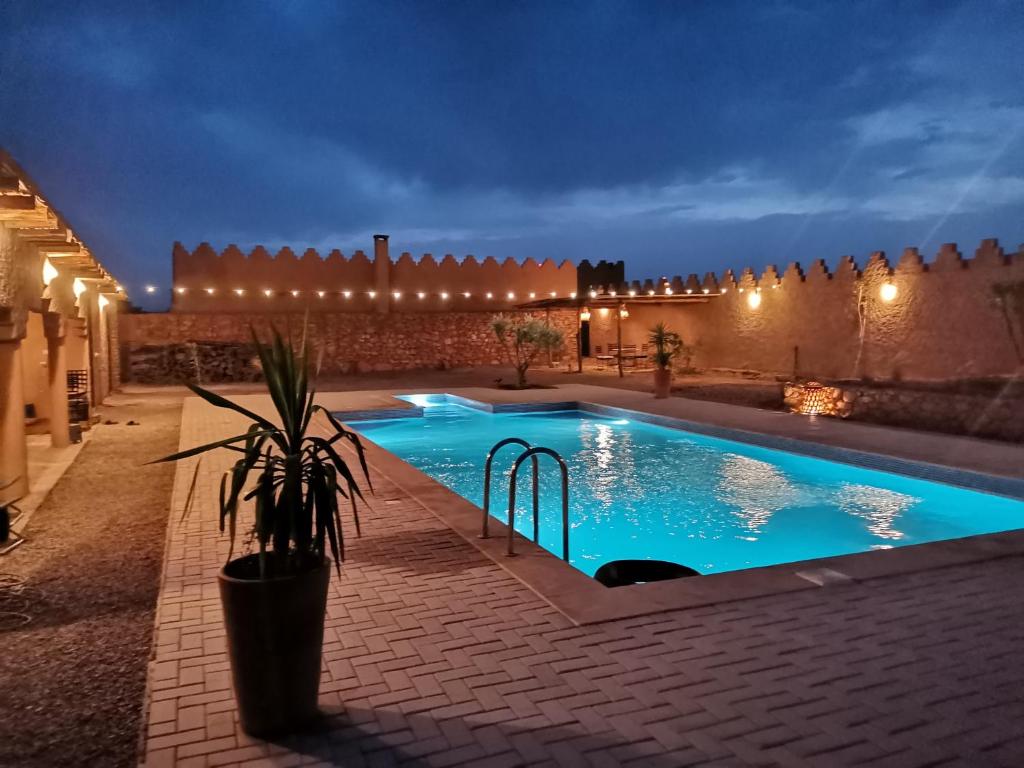 TaforhaltKsar Montana Hôtel, Chambres piscine的夜间在庭院里的一个游泳池