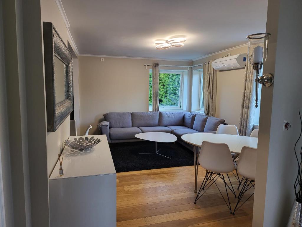 卑尔根Nesttunveien appartments的客厅配有蓝色的沙发和桌子