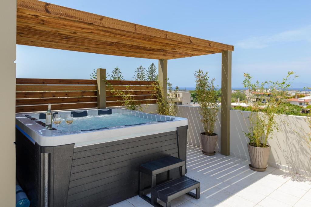 克雷马斯蒂Atlas Villa的庭院设有热水浴池和木制凉亭
