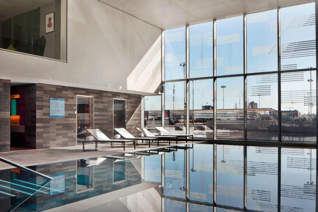 伦敦雅乐轩伦敦埃克塞尔酒店的大堂设有椅子和水游泳池