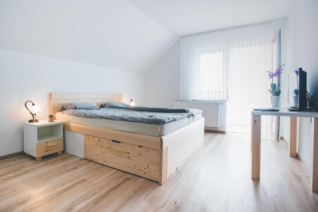 什科菲亚洛卡Apartma pri Boštjanu的一间铺有木地板的白色卧室,配有一张床