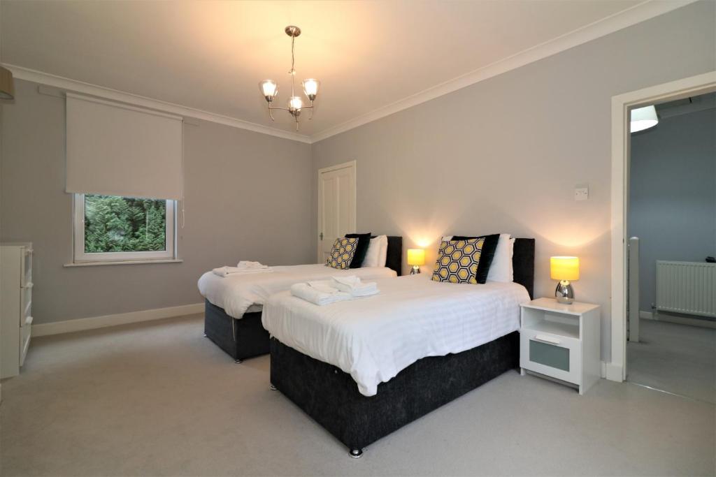 GovanSignature - Moss View的一间卧室设有两张床和窗户。