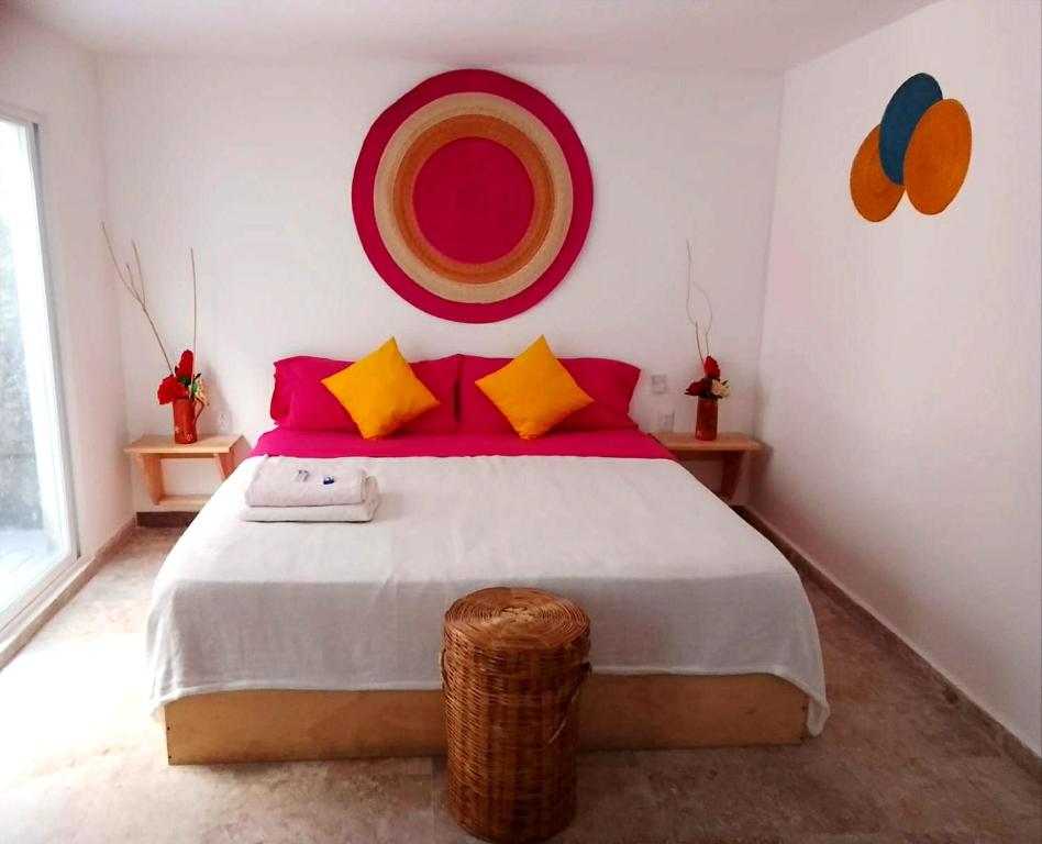 科苏梅尔Casa Isabella的一间卧室配有一张大床,提供红色和黄色枕头