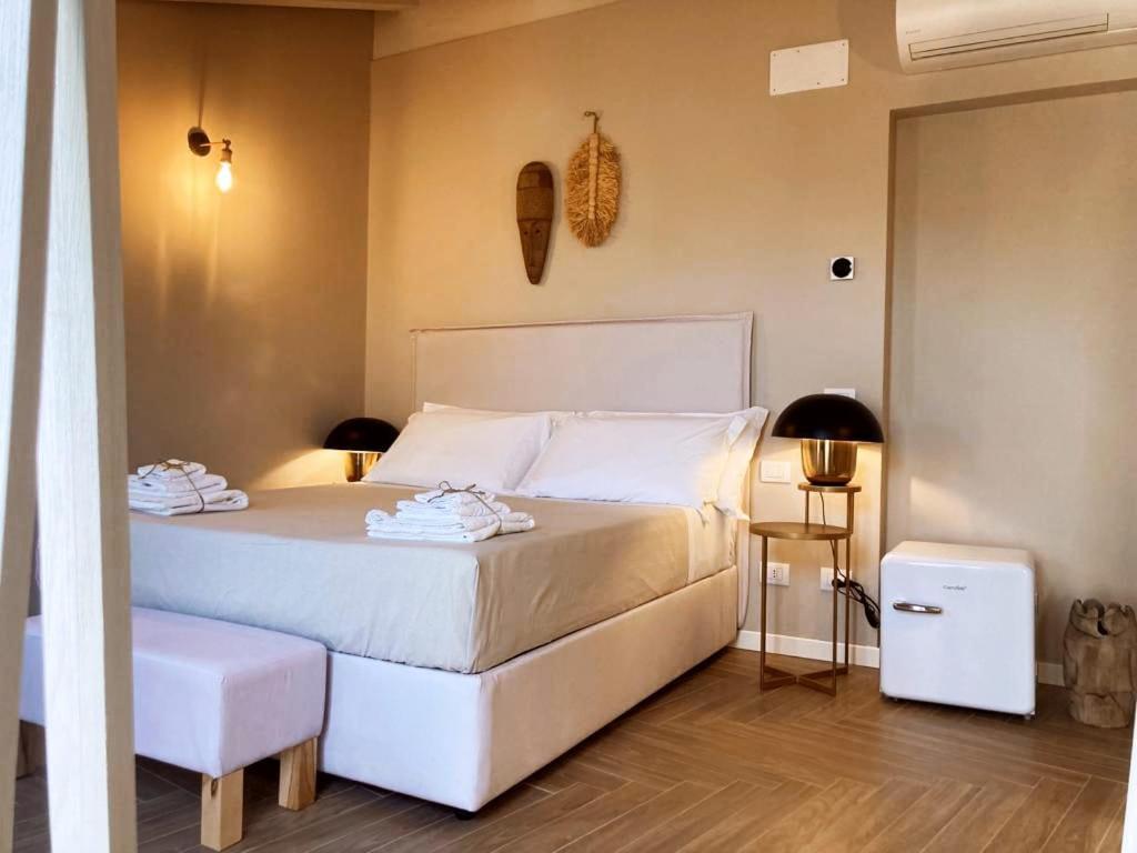 贝加莫Gatto Bianco Rooms 42的卧室配有白色的床和2条毛巾