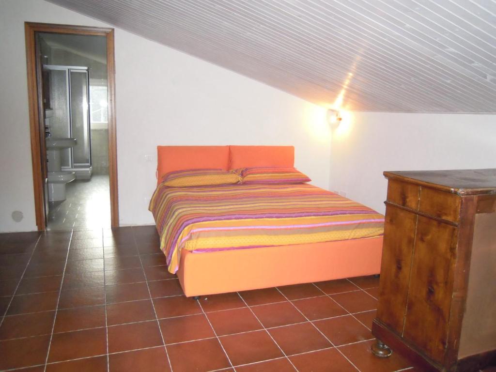 弗拉博萨索塔纳知更鸟酒店的一间卧室配有橙色的床和木制梳妆台