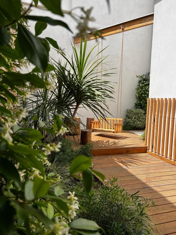 欧巴涅Lily l'Acrobate Aubagne-Cassis-Aix en Provence的木甲板上设有长凳和一些植物