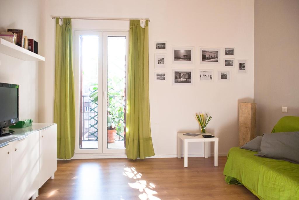 罗马欢朋迎宾公寓的客厅设有绿色沙发和窗户。