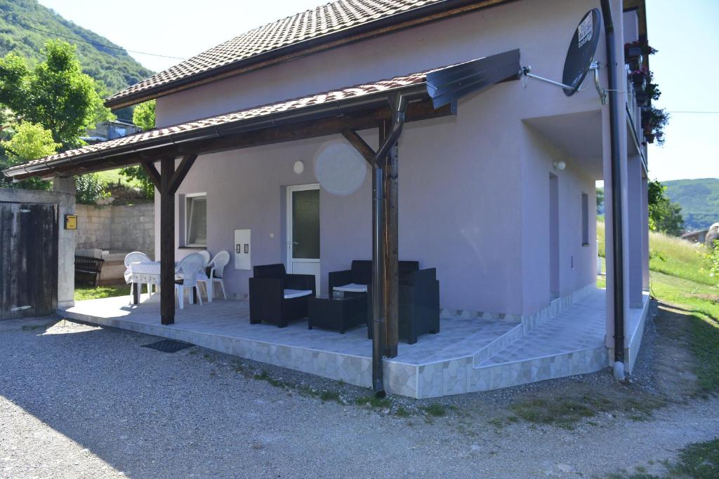 佩鲁恰茨Kuca za odmor Dragina的房屋设有带顶棚和桌子的庭院