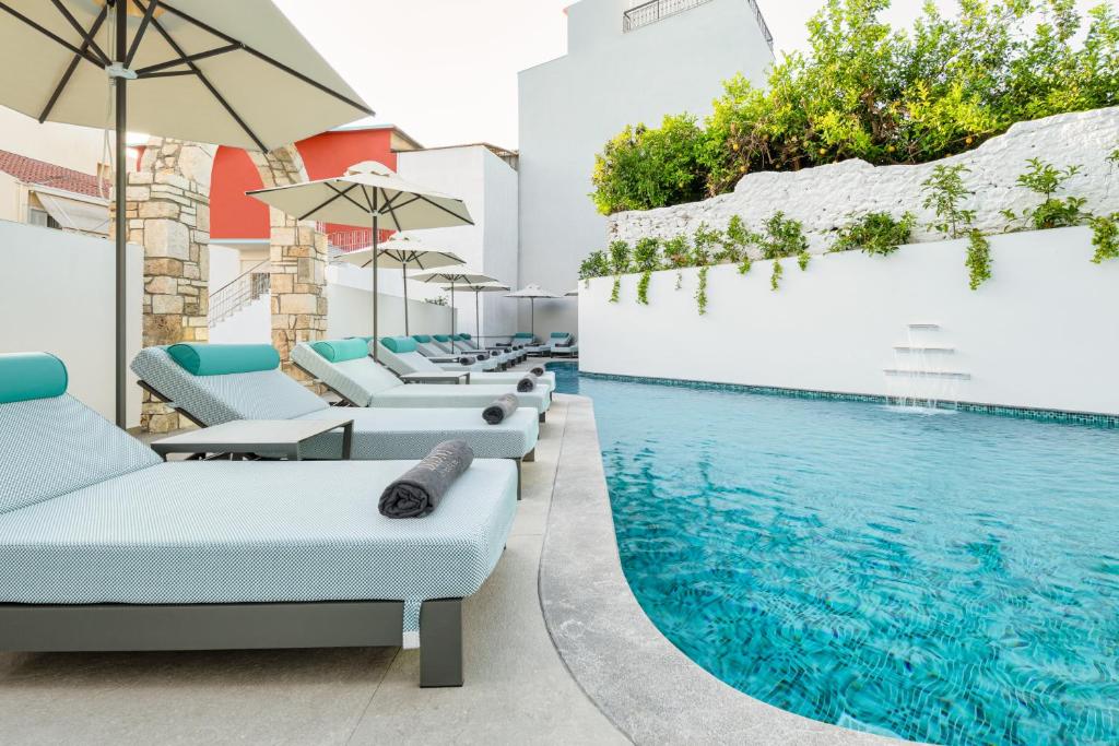 普雷韦扎迪奥尼精品酒店的游泳池旁的游泳池配有椅子和遮阳伞