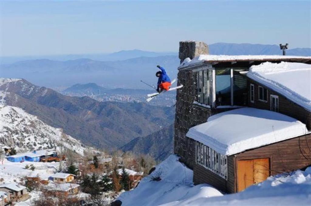 法洛伦斯Cordillera Hostel的滑雪者在雪地中跳下建筑物