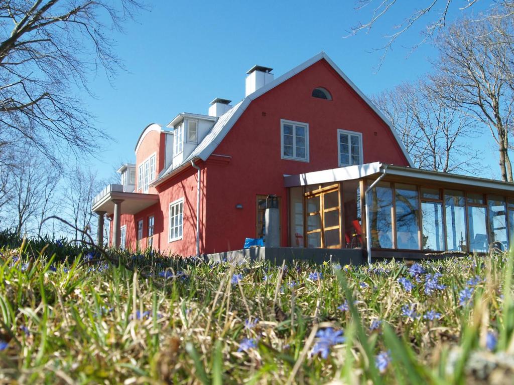 Skåne-Tranås斯道图普住宿加早餐旅馆的一座红房子,位于一座小山上,花色紫色