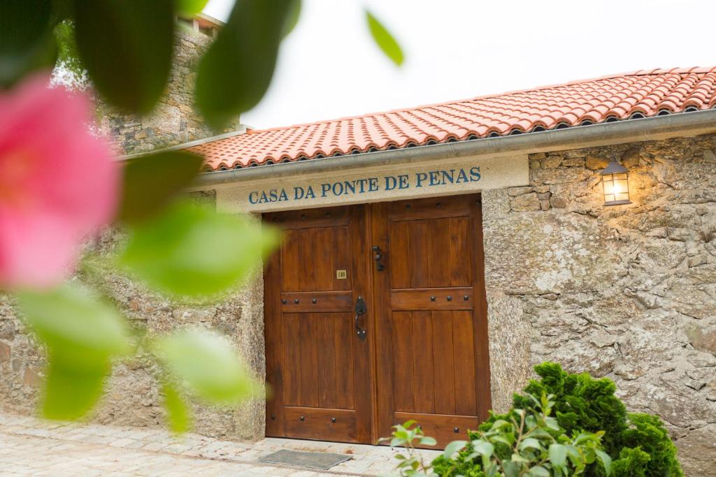 梅利德Casa da Ponte de Penas的一座带木门的建筑,上面有标志