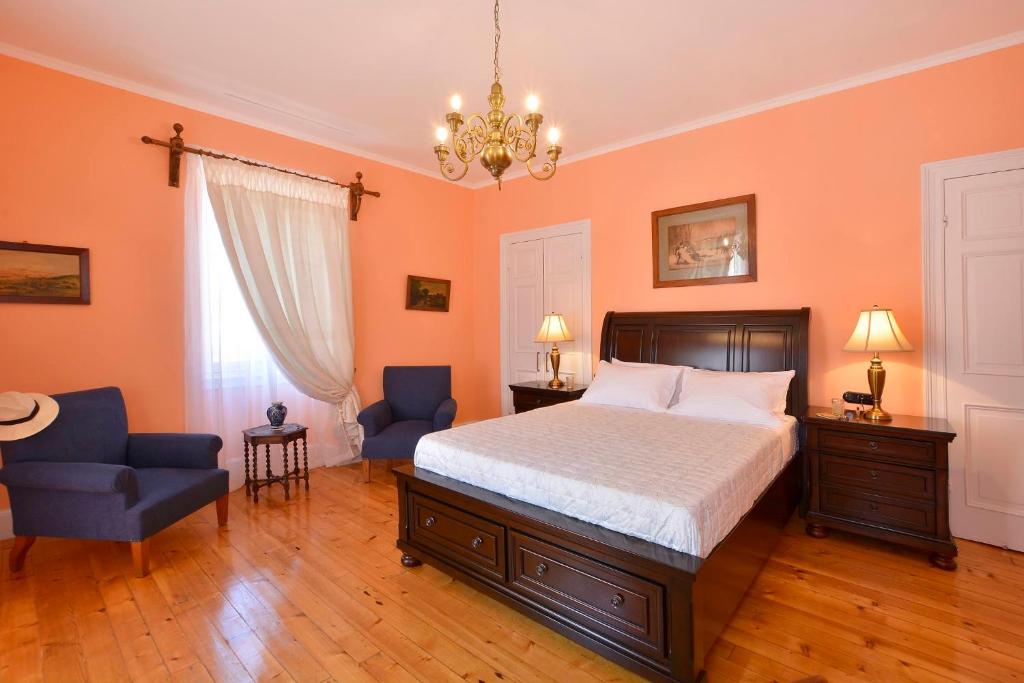 科孚镇History House的一间卧室配有一张床、两把椅子和一个吊灯