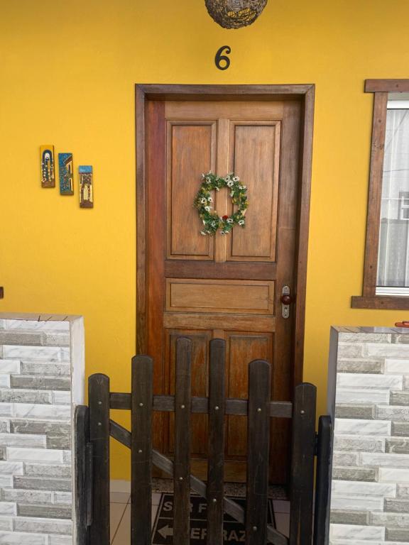 塞拉Casa beira mar Jacaraipe.的黄色墙上的木门,花圈
