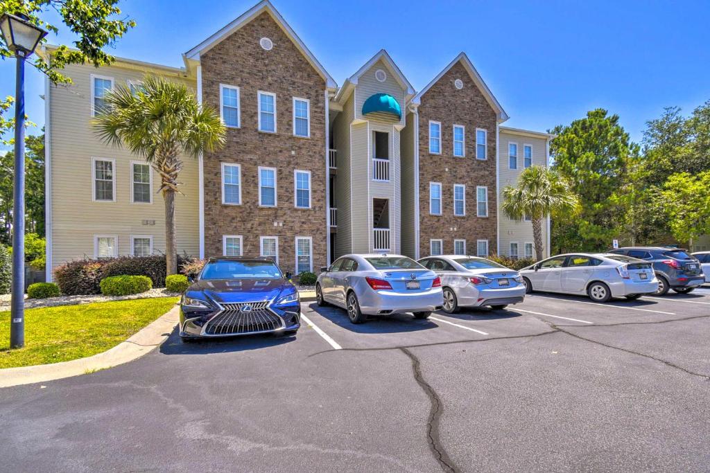默特尔比奇Less Than 2 Mi to Beach Savannah Shores Resort Condo!的停在大楼前停车场的一群汽车