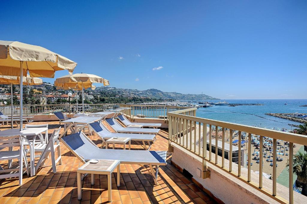 圣雷莫迪都耶波尔帝住宅酒店的一个带椅子和遮阳伞的甲板和海滩