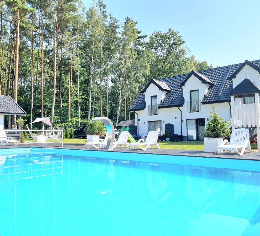 乌斯特卡Nadmorska Przystan - Apartamenty caloroczne的房屋前有游泳池的房子