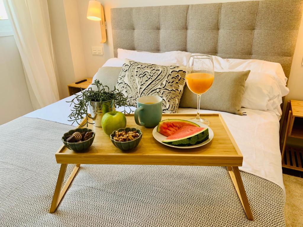 马贝拉Sea view luxury new apartment Marbella Port的床上放着一盘食物和一杯葡萄酒